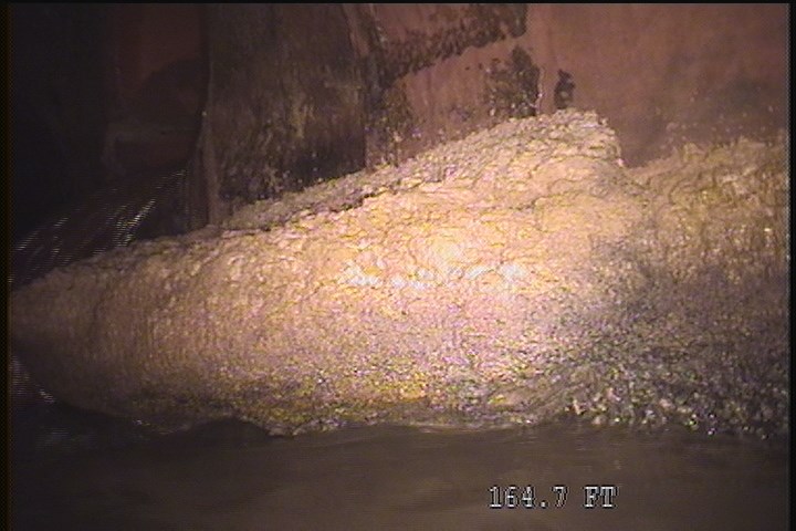 Deposits Attached Grease, 15 %of cross sectional area, from 04 to 05 o'clock, , within 8 inches of joint: NO - INSIDE MH