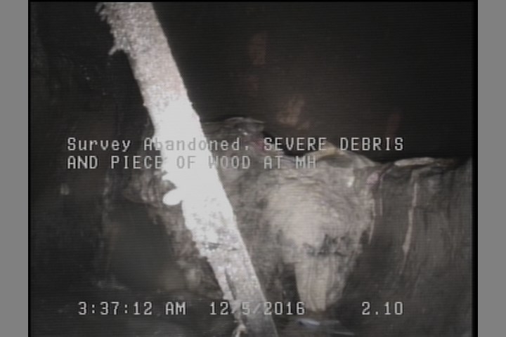 Survey Abandoned - SEVERE DEBRIS AND PIECE OF WOOD AT MH